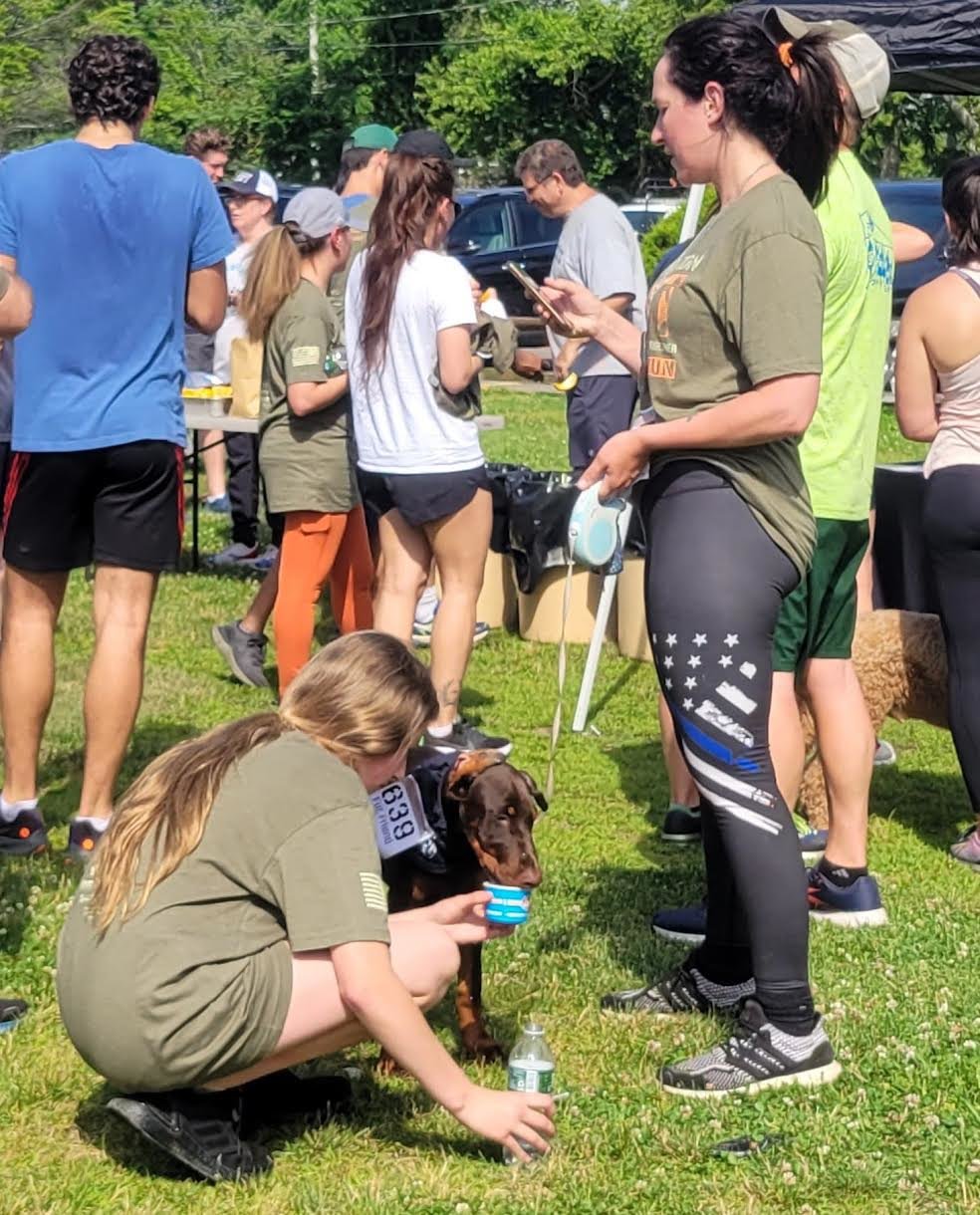 Kira Cormier and her daughter, Katie, give their Doberman water after participating in the run.